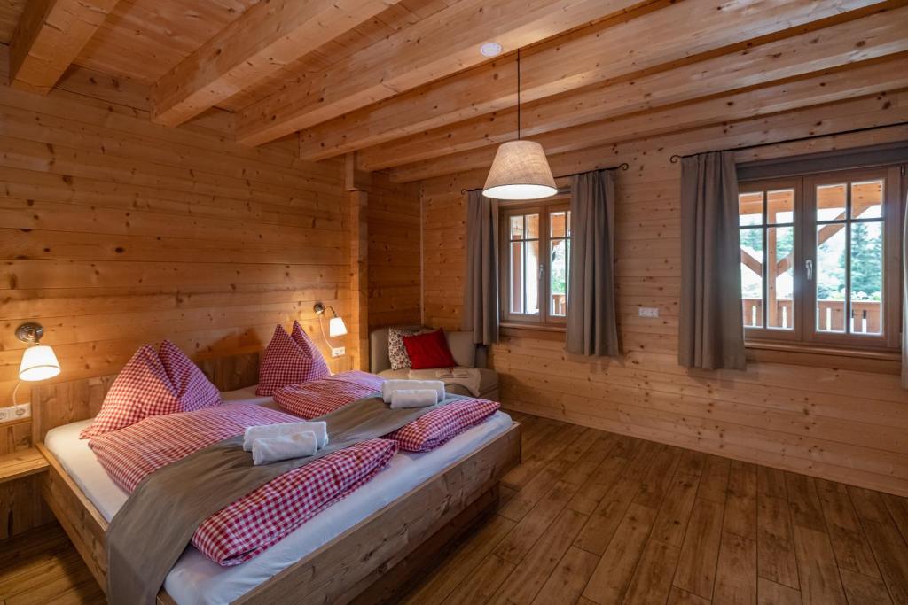 1 dormitorio con 2 camas en una cabaña de madera en Ferienwohnung Klancnik, en Bad Eisenkappel