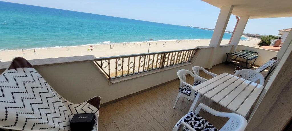 a balcony with a table and chairs and the beach at Azzurro apartamento Calabria in Marina di Strongoli