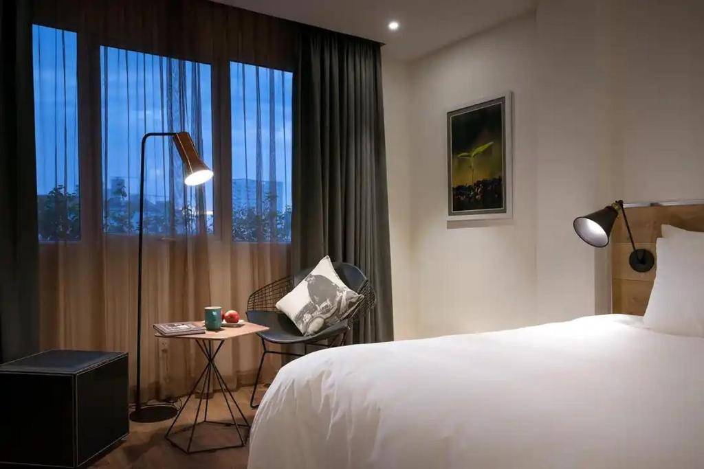 um quarto de hotel com uma cama e uma cadeira e uma janela em C Central Hotel- Đề Thám Bùi Viện Walking Street em Ho Chi Minh