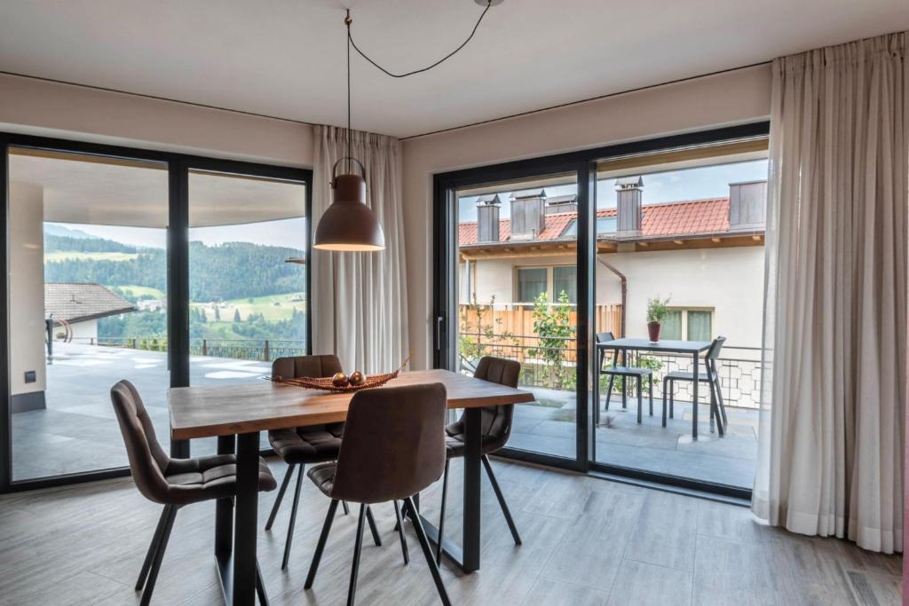 une salle à manger avec une table, des chaises et une grande fenêtre dans l'établissement Aumia Apartment Rubin, à Fiè