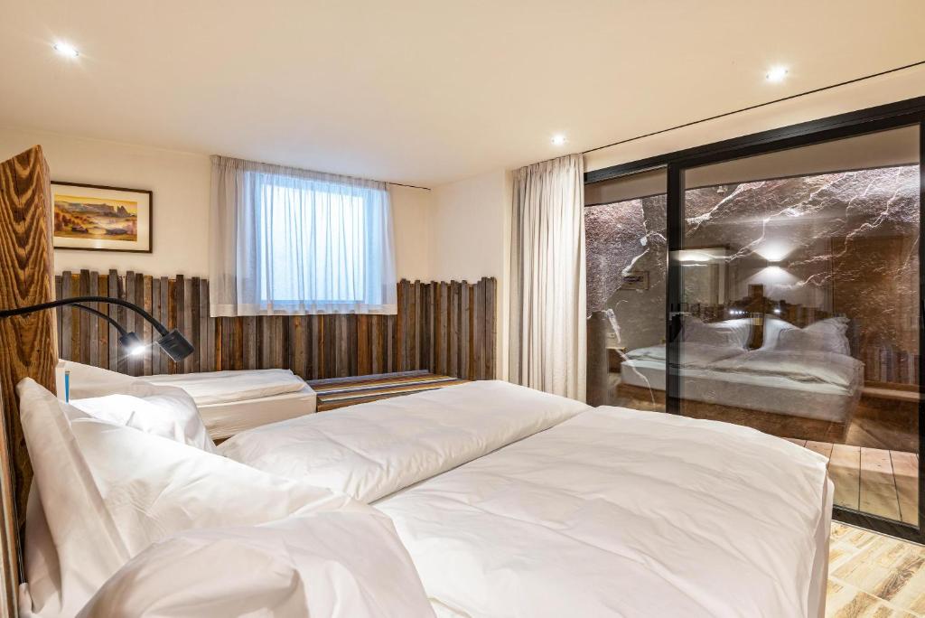 sypialnia z 2 białymi łóżkami i oknem w obiekcie Aumia Apartment Opal w mieście Fiè
