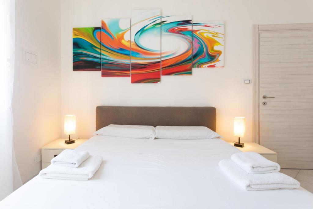 a bedroom with a white bed with two lamps at 15 - Tourist House Bologna Primaticcio - Self check-in in Bologna