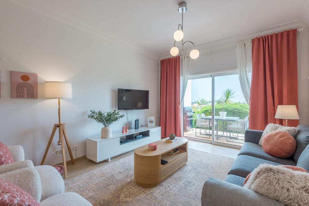 ein Wohnzimmer mit einem blauen Sofa und einem TV in der Unterkunft Boavista Charming Apartment in Lagos