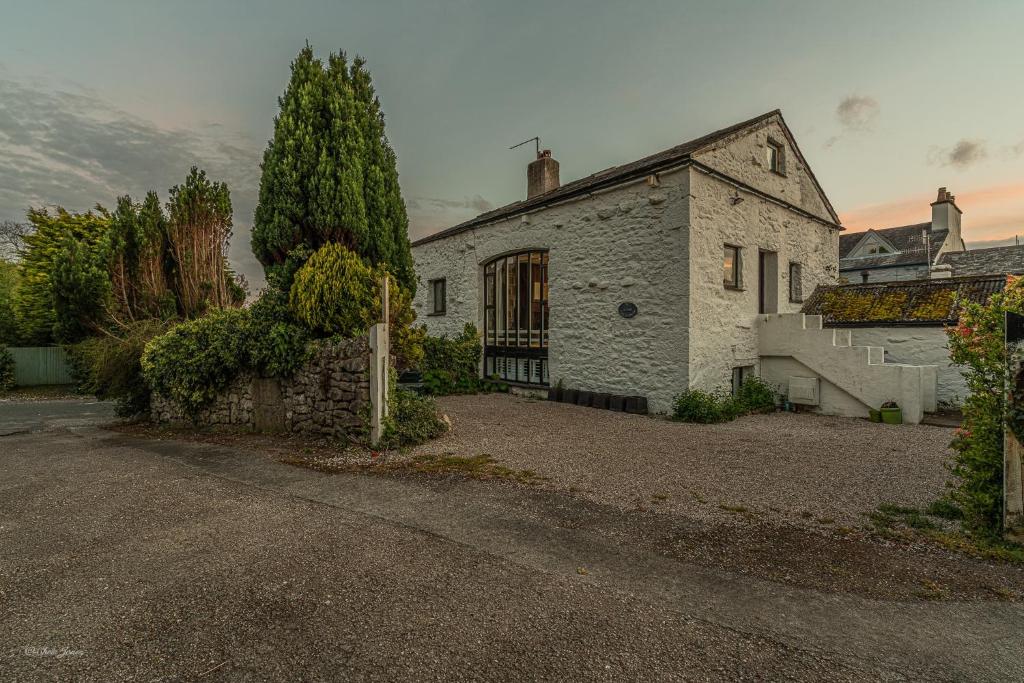 an old white brick house with a driveway at No.1 The Coach House in Silverdale