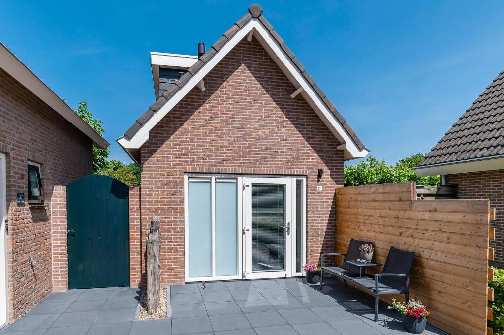 a house with a patio with a sliding glass door at Vakantiehuis '2bijZee' dicht bij Domburg en strand in Aagtekerke