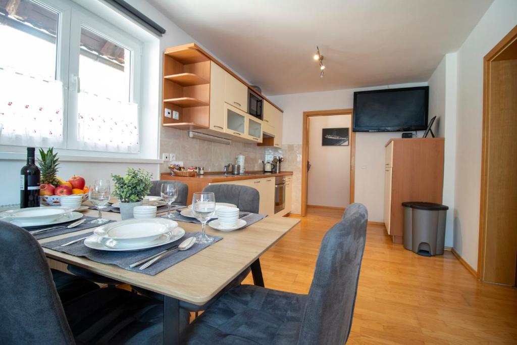 uma mesa de jantar e cadeiras numa cozinha em Apartments Pod Bregom em Kranjska Gora