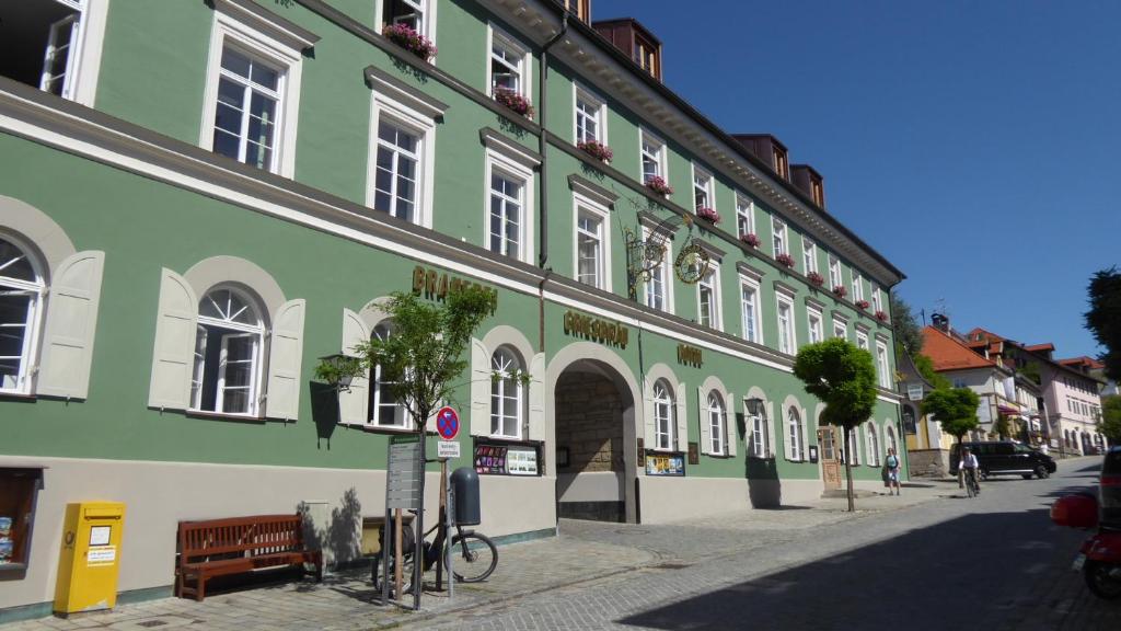 un edificio verde con una bicicleta estacionada frente a él en Griesbräu zu Murnau, en Murnau am Staffelsee