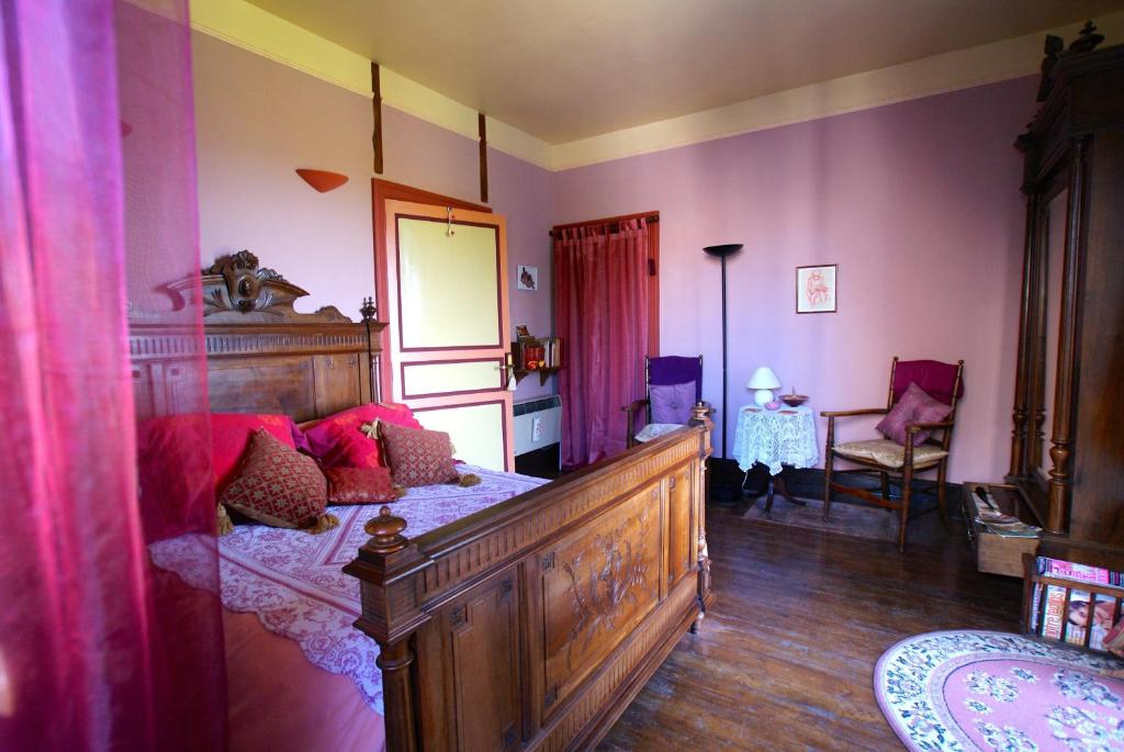 Puylaroque的住宿－萊斯奇美里斯酒店，一间卧室配有一张带红色枕头的大型木制床。