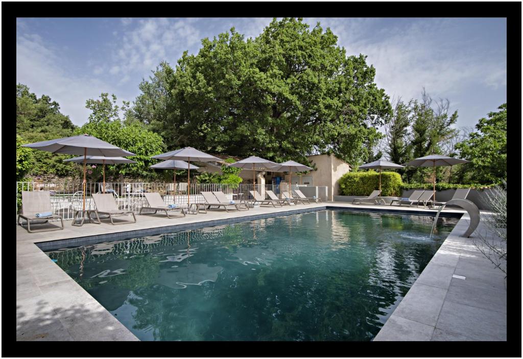 曼訥的住宿－勒馬斯都彭羅馬酒店，一个带椅子和遮阳伞的游泳池
