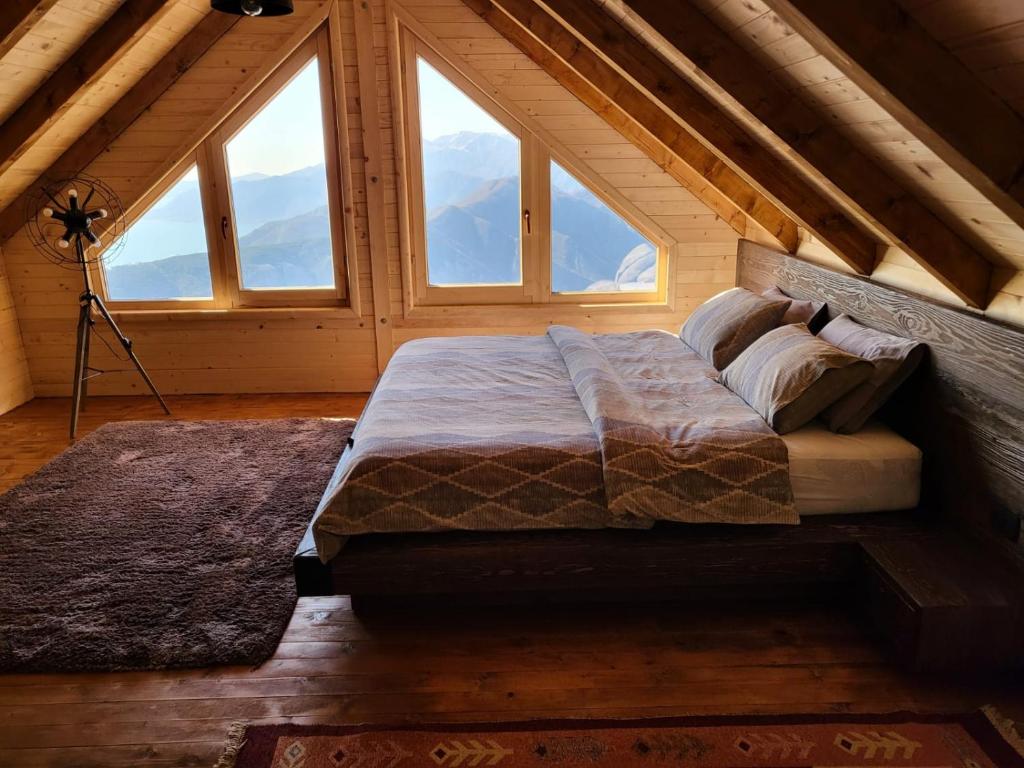 a large bed in a room with windows at Villa Skyline in Kotor