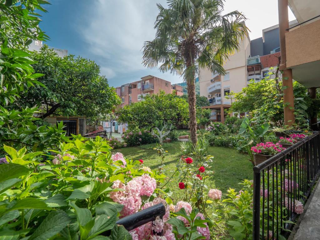 a garden with pink flowers and palm trees at Casa di Fratelli in Budva