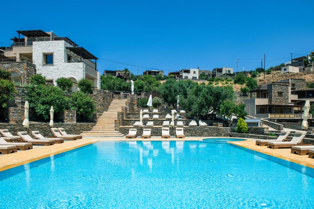 a swimming pool with chaise lounge chairs and a resort at KEA BLISS in Korissia