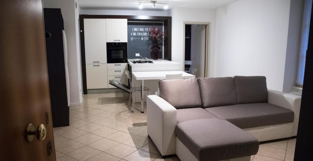 uma sala de estar com um sofá e uma cozinha em APPARTAMENTO LA CAFFETTERIA em Rovereto