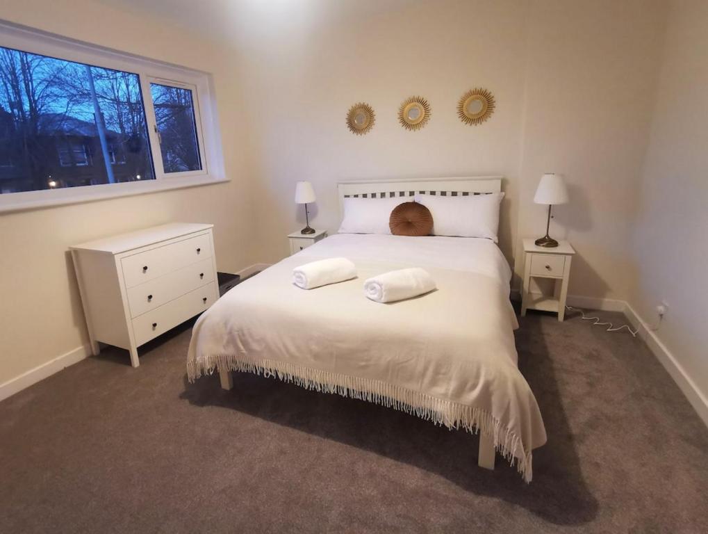 1 dormitorio con 1 cama con 2 toallas en Cosy 2 Bedroom Family Home In Glasgow City, en Glasgow