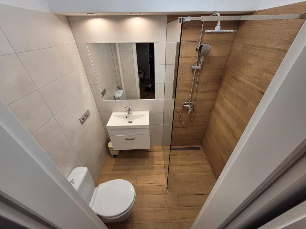 een badkamer met een douche, een toilet en een wastafel bij Apartament 5 minut spacerem od plaży in Giżycko