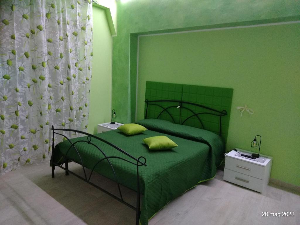 a green bedroom with a bed with green walls at ALLOGGIO VERDE nel CUORE DI SORIANO in Soriano nel Cimino