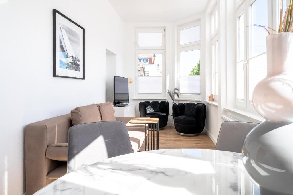 - un salon avec un canapé, des chaises et une table dans l'établissement JOHOUSE Apartment 02, à Warnemünde