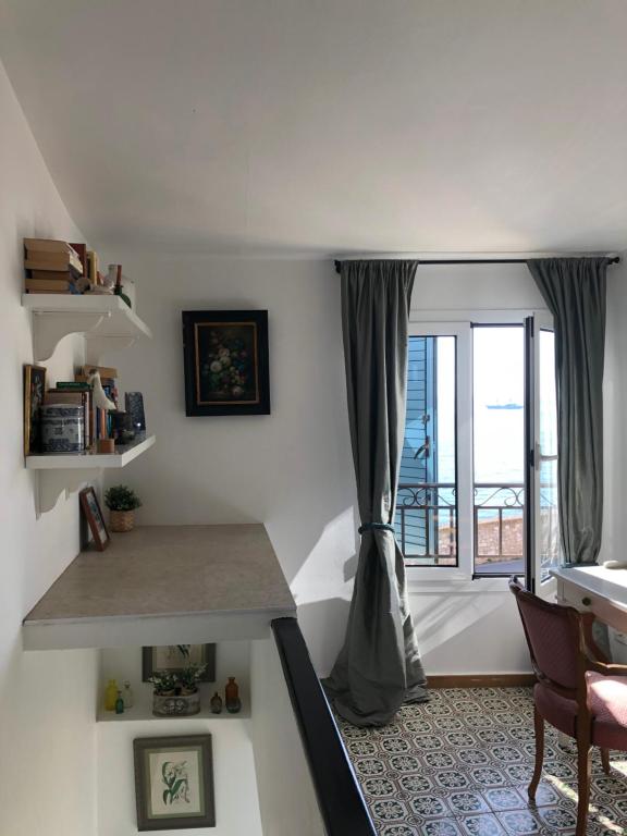 a living room with a large window and a desk at La Maisonette Antibes in Antibes
