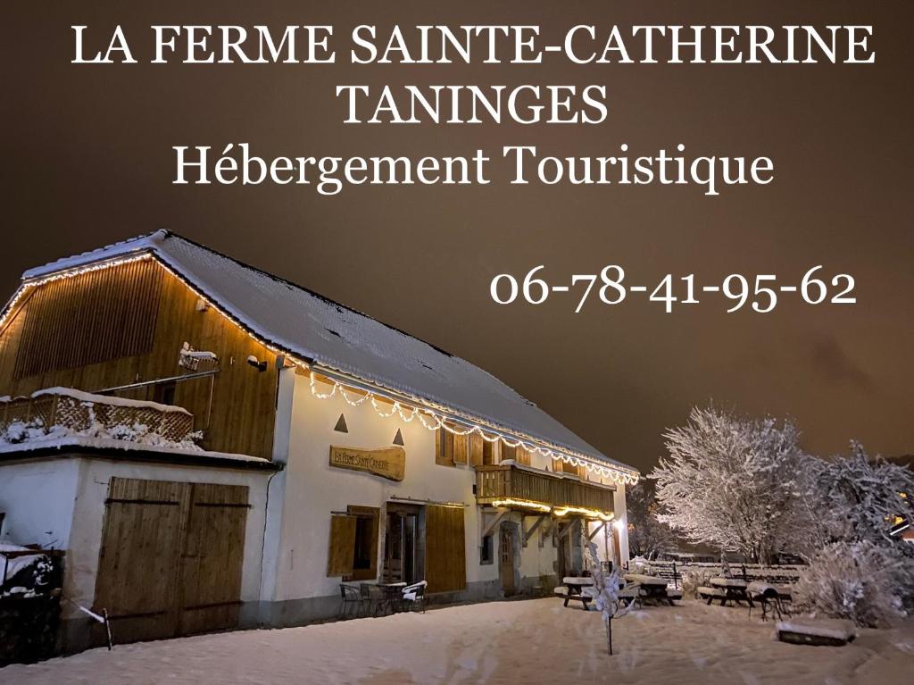 a picture of a building with snow and lights at La Ferme Sainte Catherine in Taninges