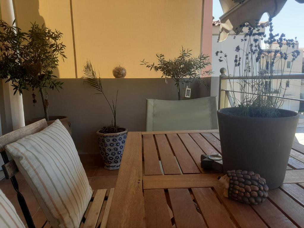 einem Holztisch mit zwei Topfpflanzen darauf in der Unterkunft Modern Apartment near Airport in Athen