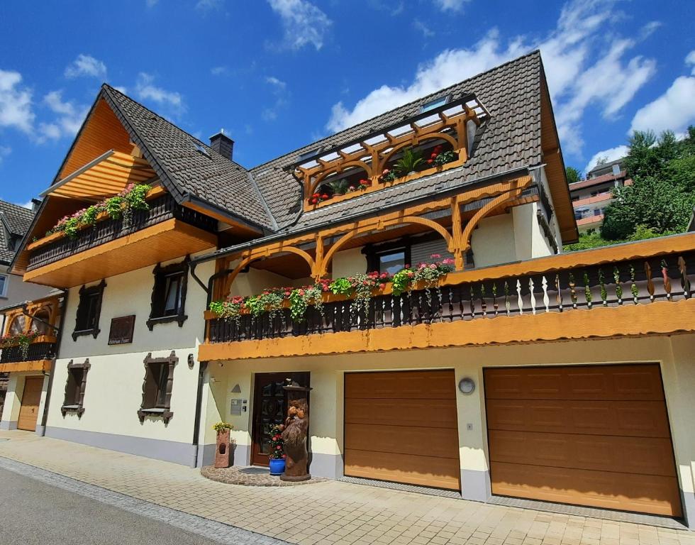 a house with two garage doors and a balcony at Gästehaus Haaser in Bad Peterstal-Griesbach