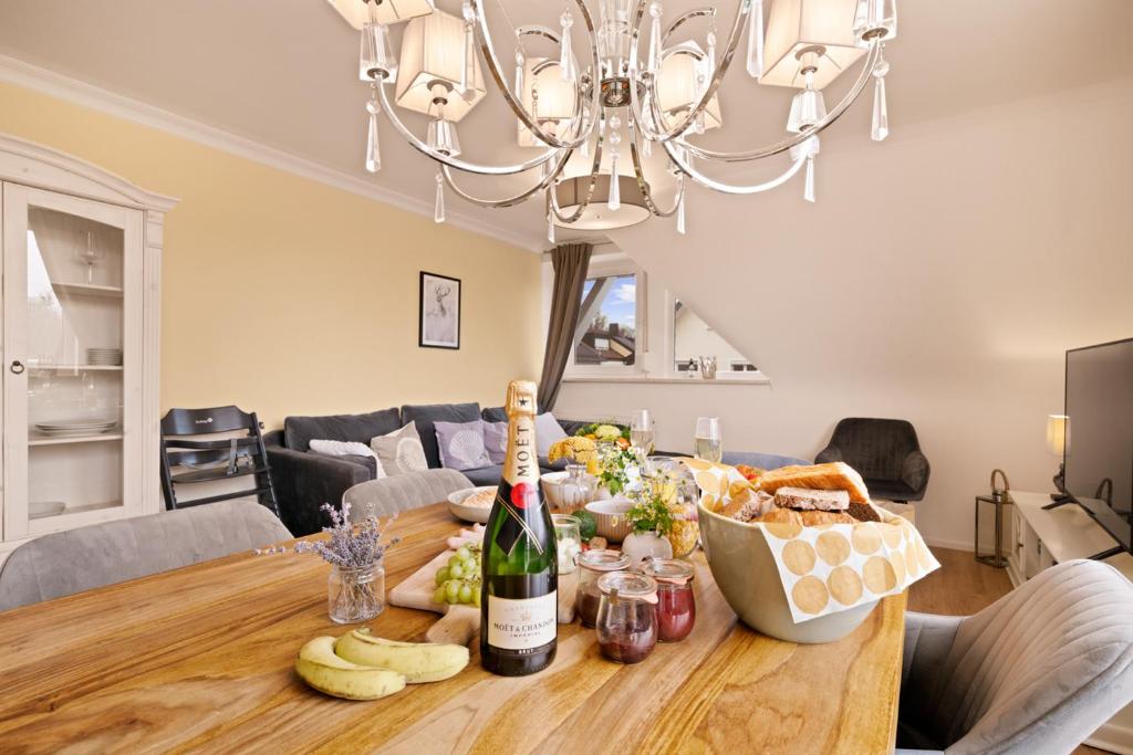 a dining room with a table with a bottle of wine and bread at Ferien-Apartment Eisvogel im Naturschutzgebiet mit Privatstrand in Friedrichshafen