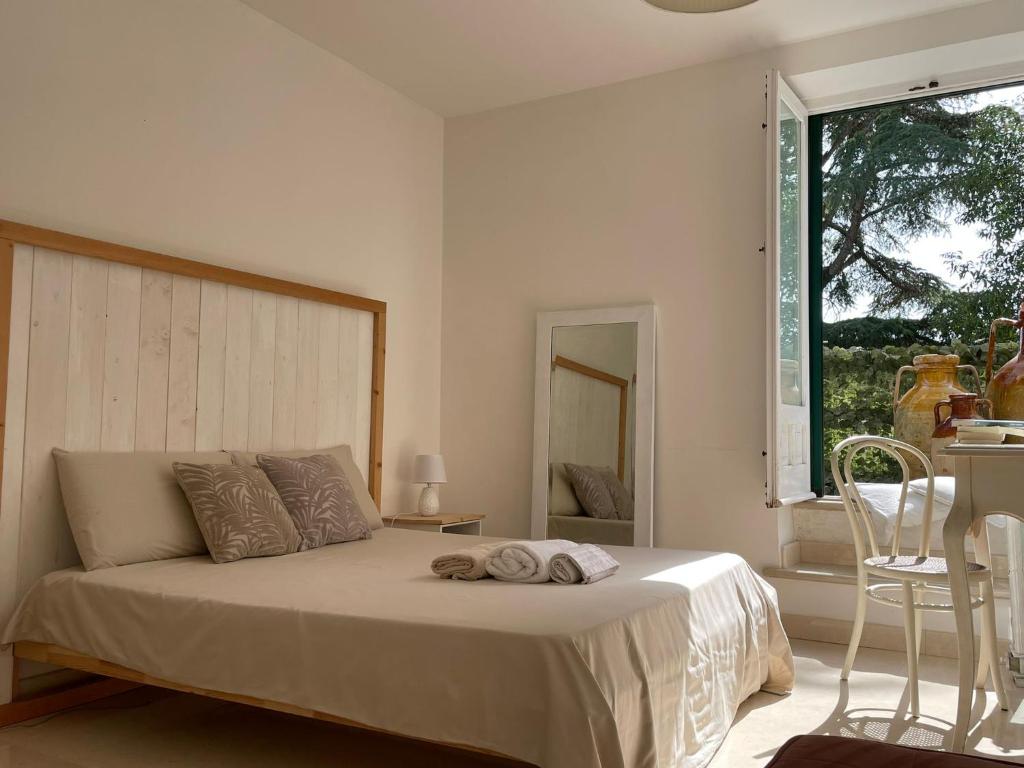 une chambre avec un lit avec une chaise et une fenêtre dans l'établissement MASSERIA INCANTAMENTO Suite Bouganville, à Latiano