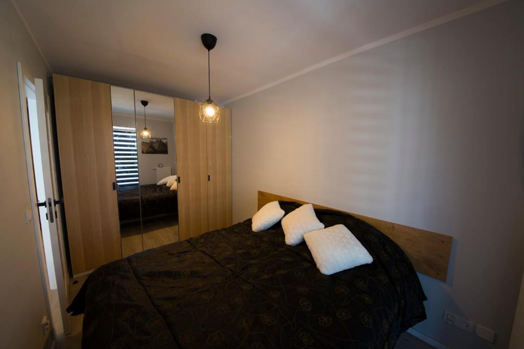 a bedroom with a bed with two pillows and a mirror at Wyspa Uznam Sun Tower in Świnoujście