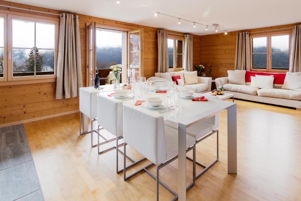una sala da pranzo con tavolo bianco in soggiorno di Chalet Bergrose 4 a Wengen