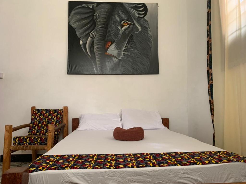 Un dormitorio con una cama con una foto de un elefante en SawaSawa Lodge Paje en Paje