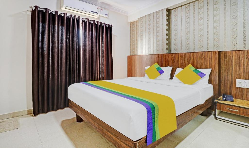 a bedroom with a large bed with a rainbow blanket at Itsy By Treebo - BCP Suites in Bangalore