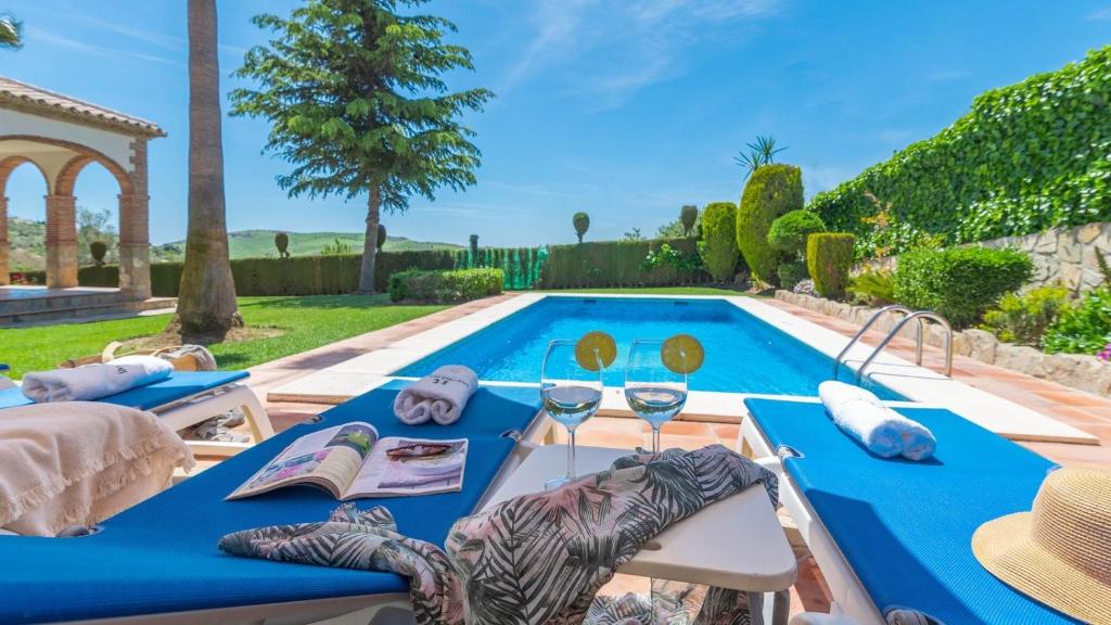 Cette villa dispose d'une piscine et d'une table avec des verres à vin. dans l'établissement Casa Los Lirios Antequera - La Higuera by Ruralidays, à Antequera