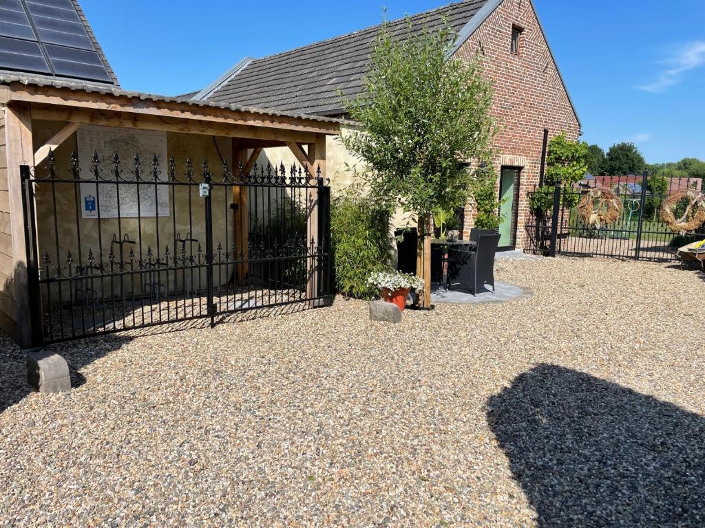 a driveway with a black gate in front of a house at Het Koerhuis in Kinrooi