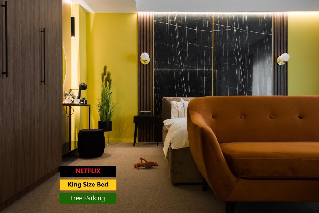 une chambre d'hôtel avec un canapé et un lit dans l'établissement Luxury Sahara Noir Mamaia Nord, à Mamaia