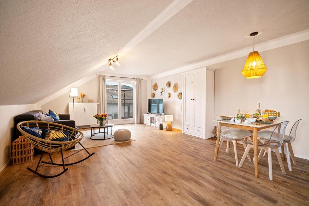 ein Wohnzimmer mit einem Tisch und einem Esszimmer in der Unterkunft Ferien-Apartment Riedperle mit Privatstrandzugang in Friedrichshafen