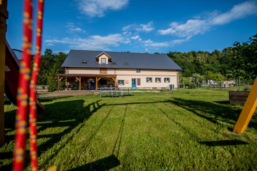 a large white barn with a large grass field at Apartmány Kraš in Velká Kraš