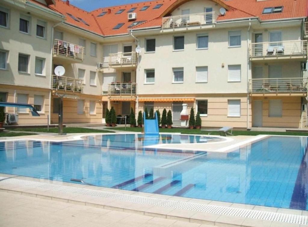 una gran piscina frente a algunos edificios en Mirage Wellness Apartman, en Hajdúszoboszló