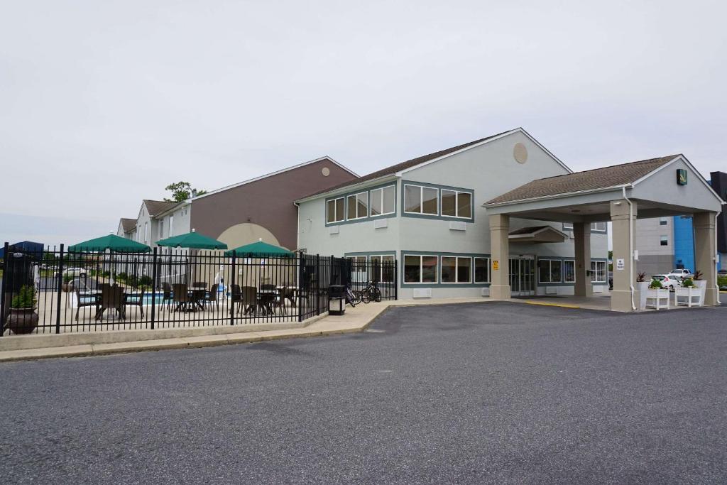 a large white building with a fence in front of it at Quality Inn & Suites Georgetown - Seaford in Georgetown