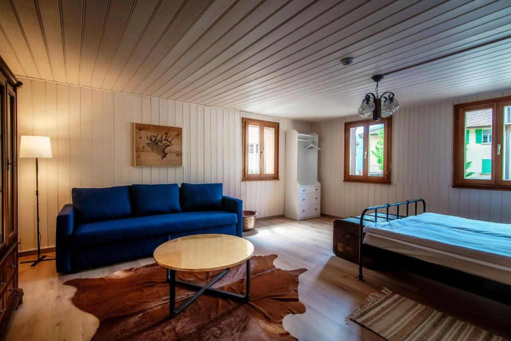 uma sala de estar com um sofá azul e uma cama em Casa Bella Oschesina by Quokka 360 - in the village of Osco em Osco