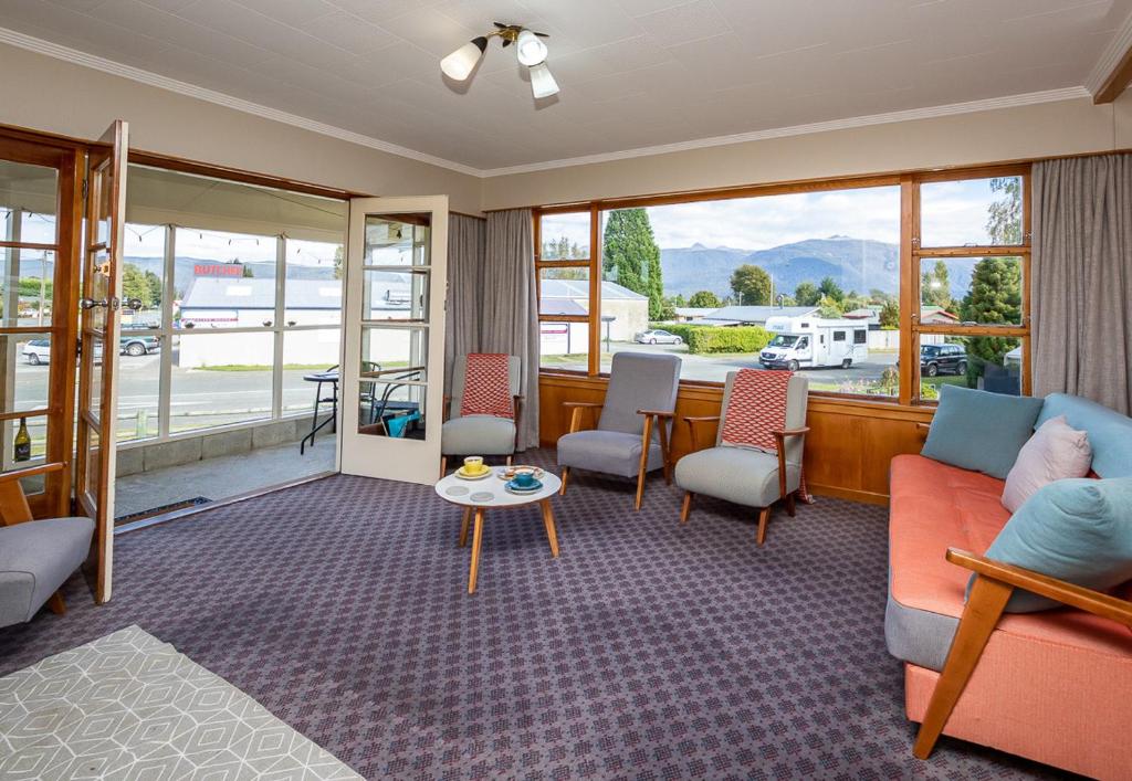 a living room with a couch and chairs and a table at Grand View - Te Anau Holiday Home in Te Anau