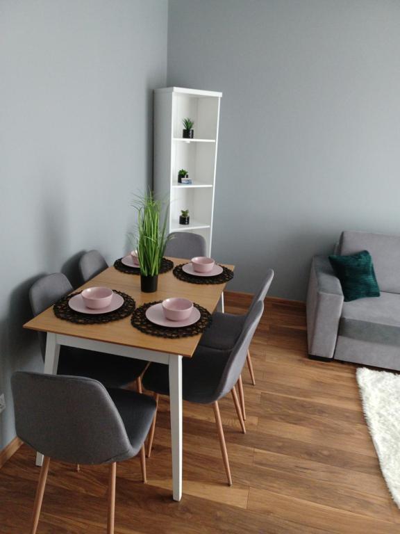 stół jadalny z 4 krzesłami i kanapą w obiekcie Apartament Miłosz w mieście Ełk