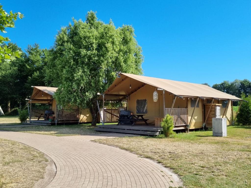 ein Gebäude mit einem Zelt und einem Gehweg in der Unterkunft Glamping Heidekamp in Versmold