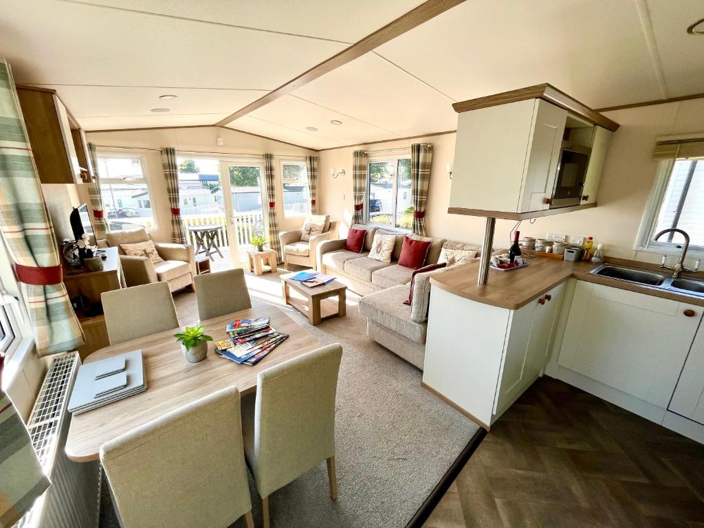 a kitchen and a living room with a table at Forget Me Not Caravan - Littlesea Haven Holiday Park, Weymouth in Wyke Regis