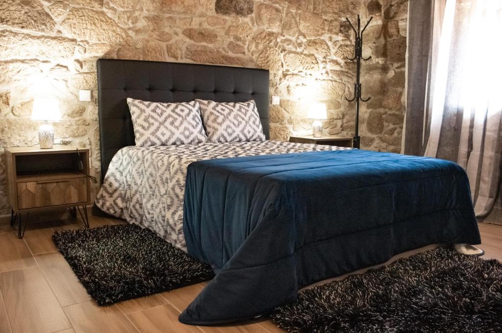 1 dormitorio con 1 cama grande con manta azul en Casa da Eira de Santo Amaro, en Ponte da Barca