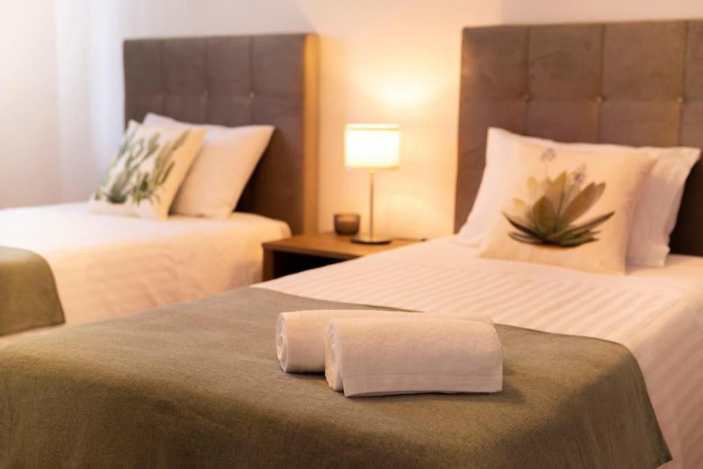 a hotel room with two beds with a towel on the bed at EntreVillas Alojamento Local, apartamento T2 in Arcos de Valdevez