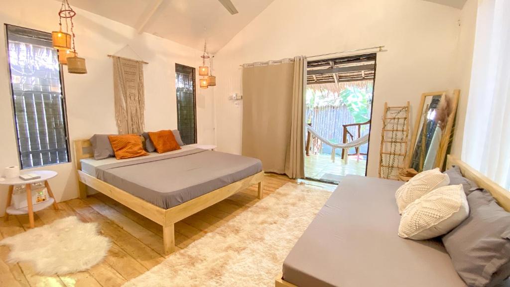 a bedroom with two beds and a couch at Monkey Business in Siquijor