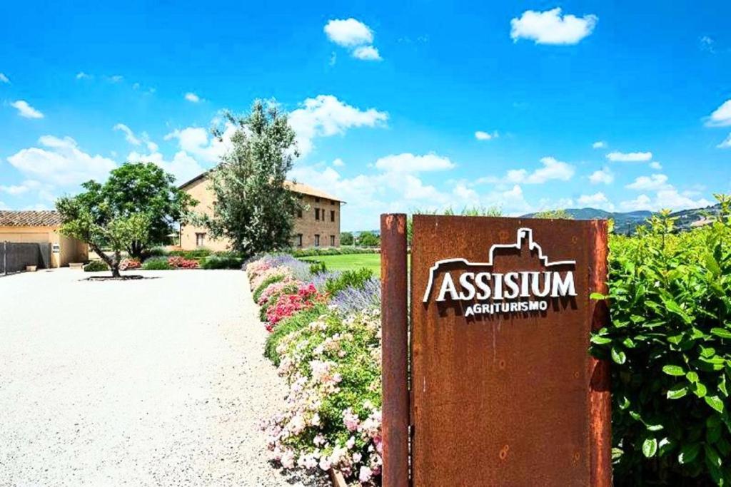 ein Schild vor einem Gebäude mit Blumen in der Unterkunft Assisium Agriturismo in Assisi