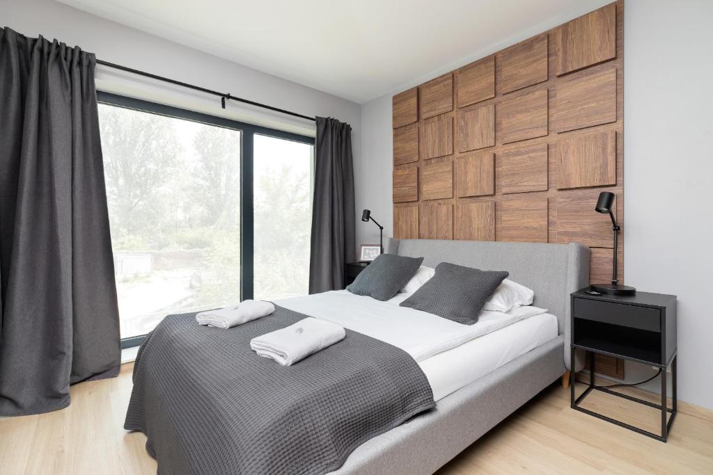 a bedroom with a bed and a large window at Modern Apartments Śródmiescie Kraków by Renters in Krakow