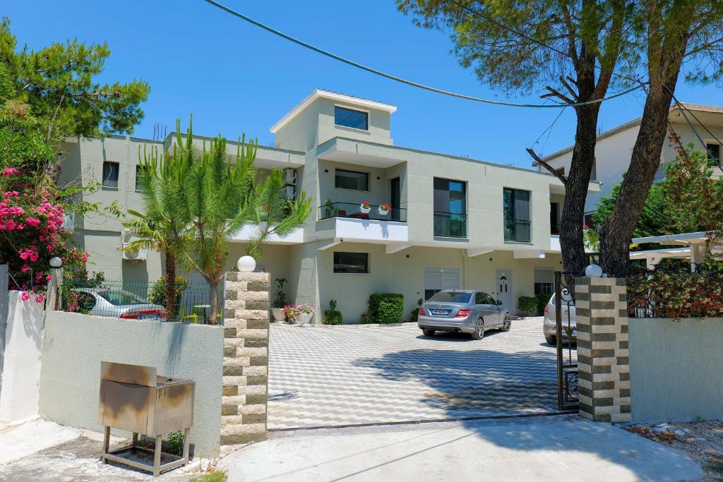 een wit huis met een auto ervoor geparkeerd bij Vila Celaj in Vlorë