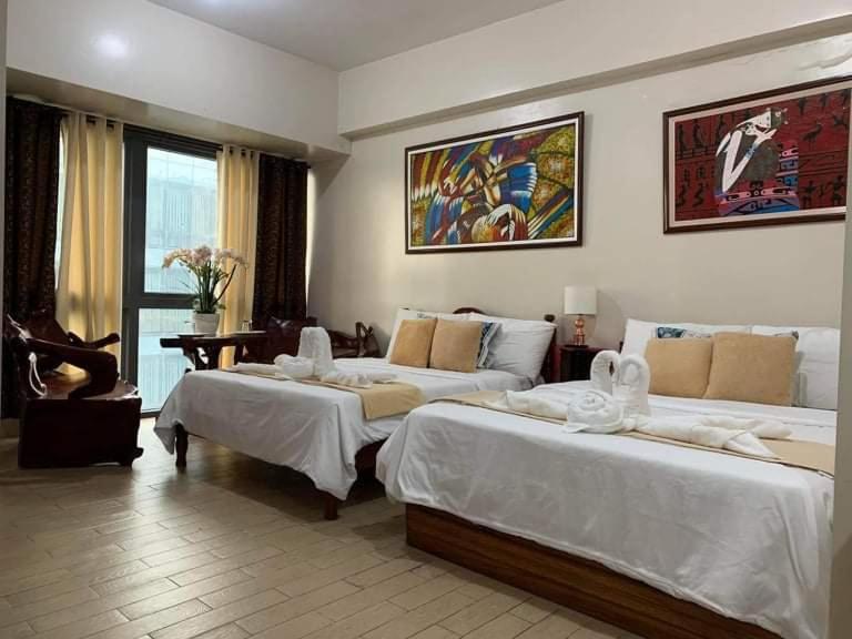 Habitación de hotel con 2 camas con sábanas blancas en CozyVilla at 81 Newport Blvd Across NAIA T3 for 5 Pax with FREE PARKING en Manila